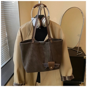 Detail of vintage large capacity tote bag with grey-brown body and dark brown handles