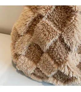 Macro shot of soft plush checkered fabric detail in brown and beige tones on a tote bag