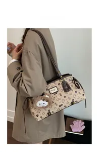 Close-up of cream retro tote bag featuring bear heart prints and plush bear pendant detail