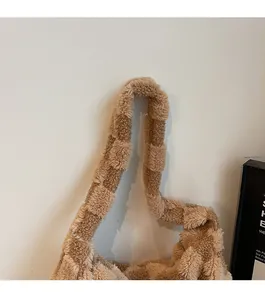 Detail of plush checkerboard tote bag showing the soft texture of its thick shoulder strap