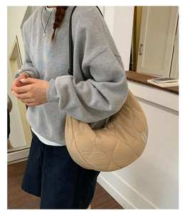 Dettaglio della borsa a mezzaluna trapuntata beige con elegante trama a rombi cucita