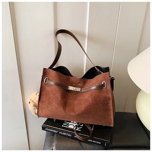 Detail of dark brown matte suede tote bag with leather strap and metal twist lock