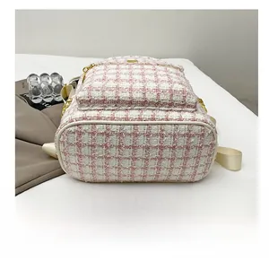 Close-up of pink tweed backpack featuring a durable reinforced white bottom base