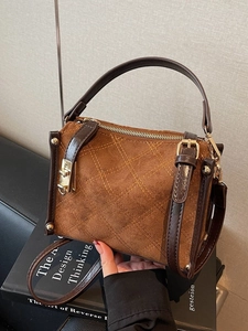 Deep brown quilted faux suede Boston bag with gold hardware and top handle for women