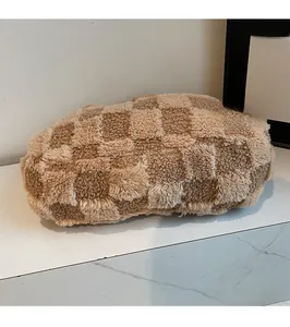 Close-up of brown checkerboard plush texture on a large crossbody shoulder bag