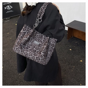 Détail d'un sac cabas léopard avec bandoulière en chaîne et étiquette tissée