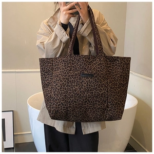 Selfie miroir montrant le grand sac cabas à imprimé léopard avec poche frontale pratique