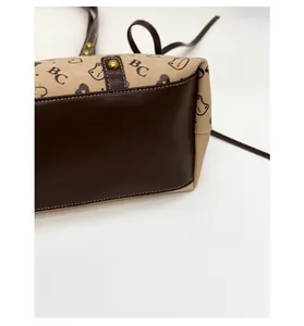 Close-up of the reinforced brown leather base on the beige canvas printed tote bag