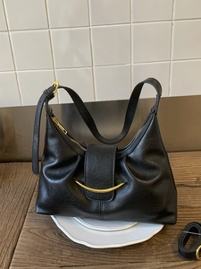 Elegant black leather dumpling bag with gold hardware buckle and adjustable strap