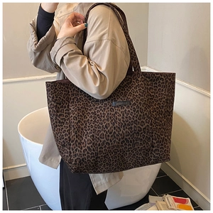 Détail d'un sac cabas en toile à imprimé léopard avec poche avant et bandoulière longue