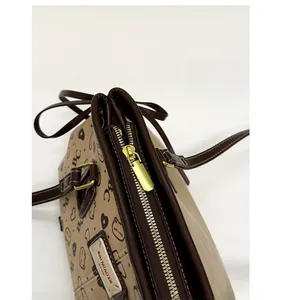 Detailed close-up of the premium golden zipper and brown leather texture on a tote bag