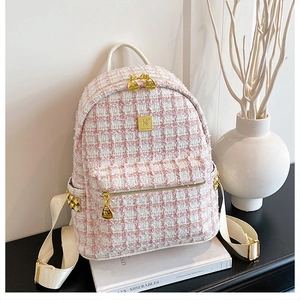 Detail of pink and white tweed texture on a stylish backpack with golden hardware accents