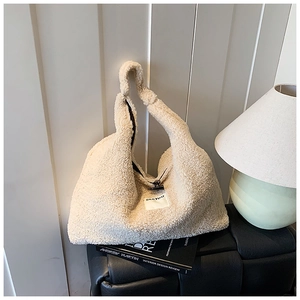 Detail of plush lamb wool tote bag featuring a horn button closure and textile label
