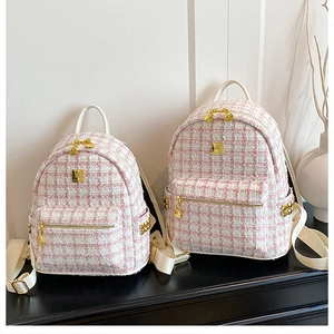 Detail of pink tweed backpack showing textured fabric and golden rivet decorations