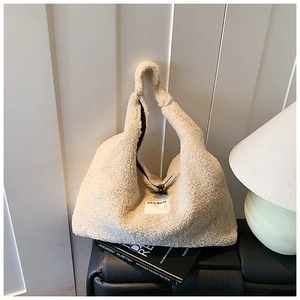 Close-up of fluffy cream lamb wool tote bag with SEEYOU label and black zipper detail