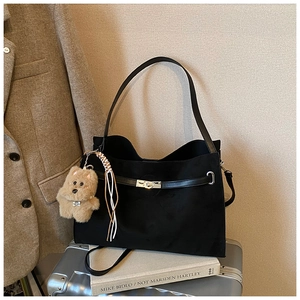 Detail of black matte tote bag featuring silver twist lock and luxury accessory charms