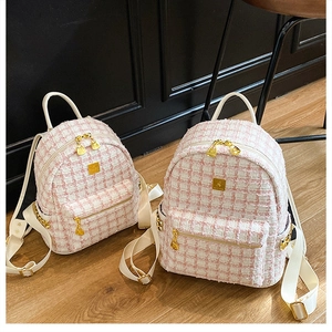 Close-up of pink and white tweed texture backpack with golden zippers and hardware