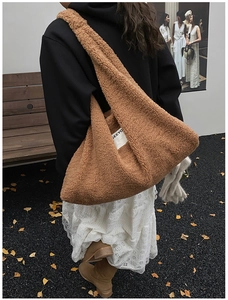 Brown faux shearling tote bag worn by a model in an autumn park with ginkgo leaves