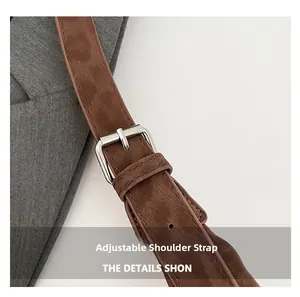 Macro detail of brown leather adjustable shoulder strap with silver metal buckle on tote bag