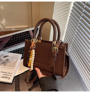 Détails du sac vintage en suède avec poignées tressées et perles en bois colorées
