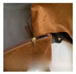Detail of dark brown suede inner pouch featuring a premium golden metal zipper closure