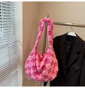Detailed macro view of soft pink checkered plush shoulder bag with thick fuzzy texture
