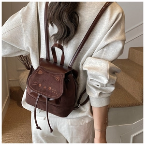 Détail d'un mini sac à dos marron avec rabat en forme de chat et broderies d'oreilles