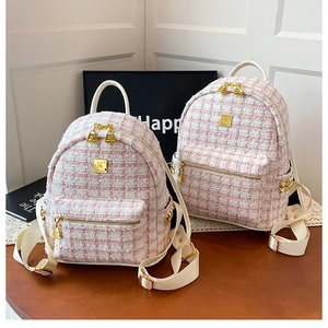 Detail of pink and white tweed mini backpacks with gold hardware and top handle