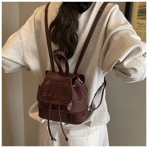 Détail d'un mini sac à dos chat marron foncé avec broderies et fermeture à cordon coulissant
