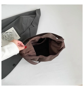 Interior view of large brown tote bag showing main compartment and zipper pocket