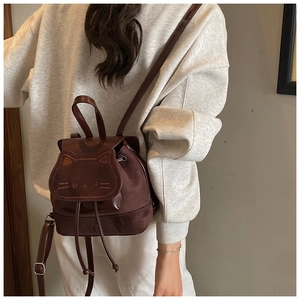 Vue détaillée du petit sac à dos bordeaux avec rabat chat et texture suède