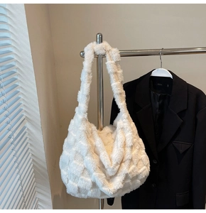 Detail of white plush tote bag with checkered texture hanging next to black blazer