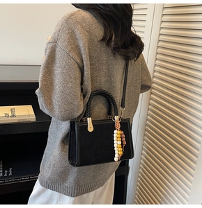 Sac bandoulière en suédine noire avec poignées tressées et breloque en perles colorées
