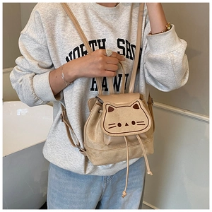 Détail du sac à dos en daim abricot avec motif de chat brodé et fermeture à cordon
