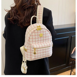 Detail view of pink and white tweed backpack with gold metal hardware and fabric strap