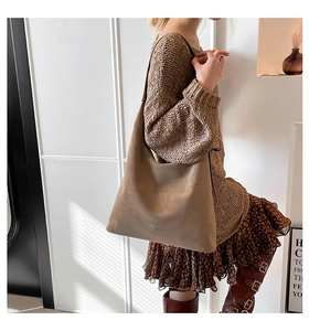 Detail view of the brown hobo bag showing supple leather texture and large capacity fit