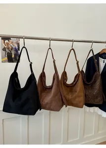 Detail of four multi-color vintage velvet tote bags with adjustable metal buckle straps