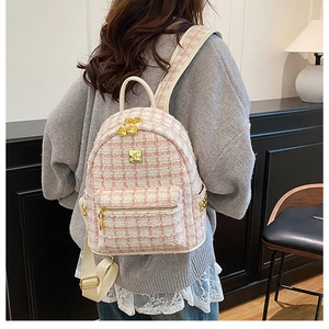 Detail of pink and white tweed backpack with gold heart zippers and lace trim lining