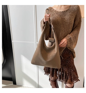 Close-up of vintage brown leather tote bag showing smooth matte texture and hobo style