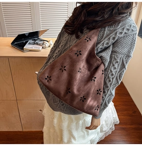 Detail of laser-cut floral pattern on dark brown faux suede large capacity tote bag