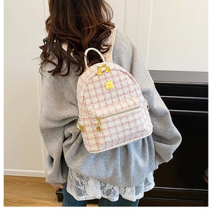 Detailed view of mini pink tweed backpack with luxury gold-tone metal hardware
