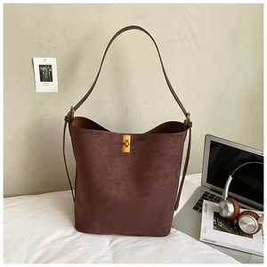 Macro shot of dark brown suede bucket bag featuring a premium gold rectangular turn-lock buckle