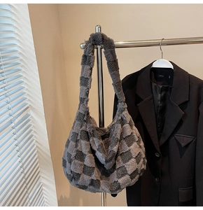 Detail view of plush checkered shoulder bag in gray faux fur with spacious interior
