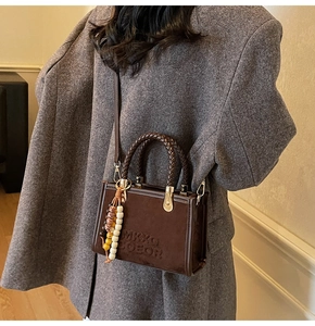 Petit sac bandoulière en suédine marron avec poignée tressée et pendentif perlé