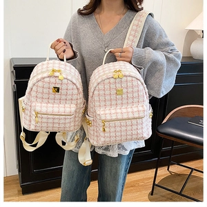 Detail of pink and white tweed mini backpack with elegant golden logo plaque