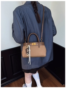 Detailed back view of vintage canvas and leather bucket bag with woven chain strap charm