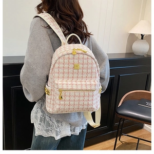 Detail of pink and white tweed backpack featuring gold hardware and metallic logo