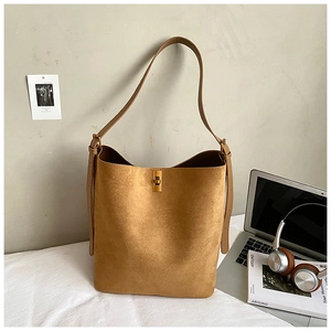 Detail of camel suede bucket bag with gold twist lock and adjustable shoulder strap
