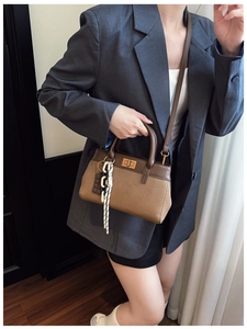 Détail de sac seau en toile bicolore avec bordure en cuir et fermoir rotatif doré