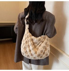 Detail view of large checkered faux fur hobo bag showing texture and autumn style